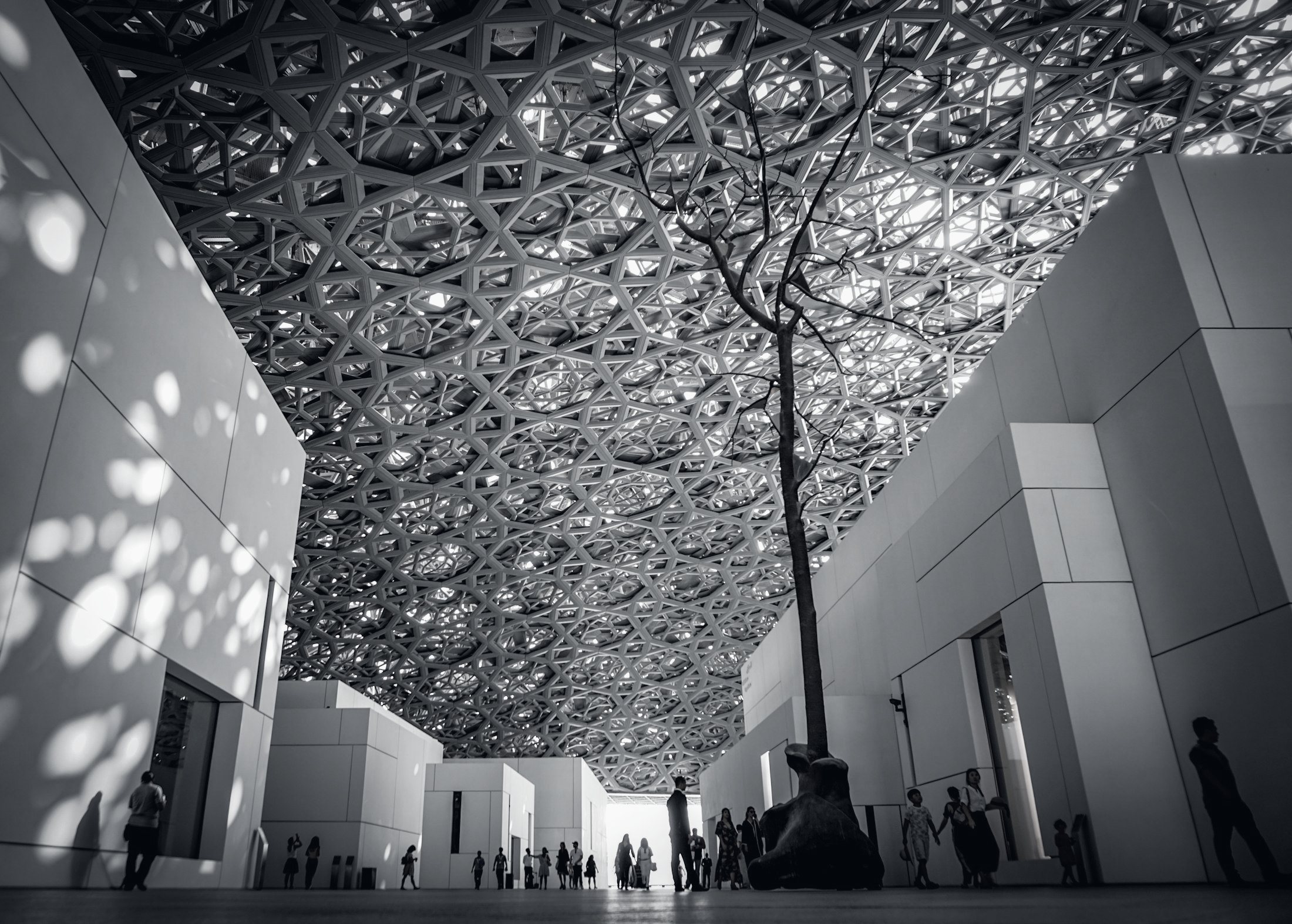 Louvre Abou Dabi : la lumière tombe à travers la coupole ajourée sur des galeries blanches